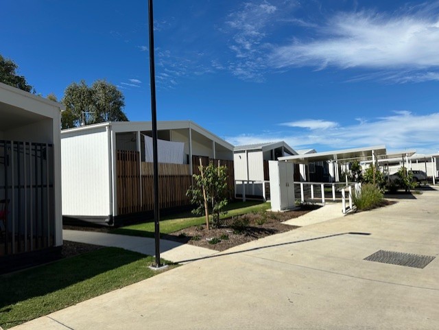 Accommodation village streetscape with lawn and planted edges.